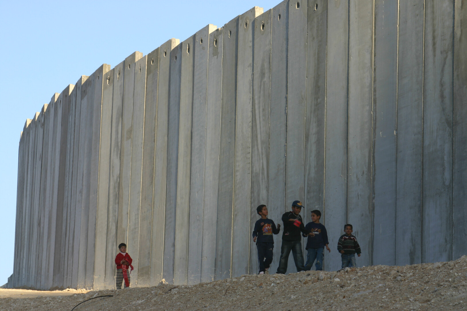 Kinderen wandelen langs een zes meter hoge muur alsof het normaal is, wat het voor hen is.